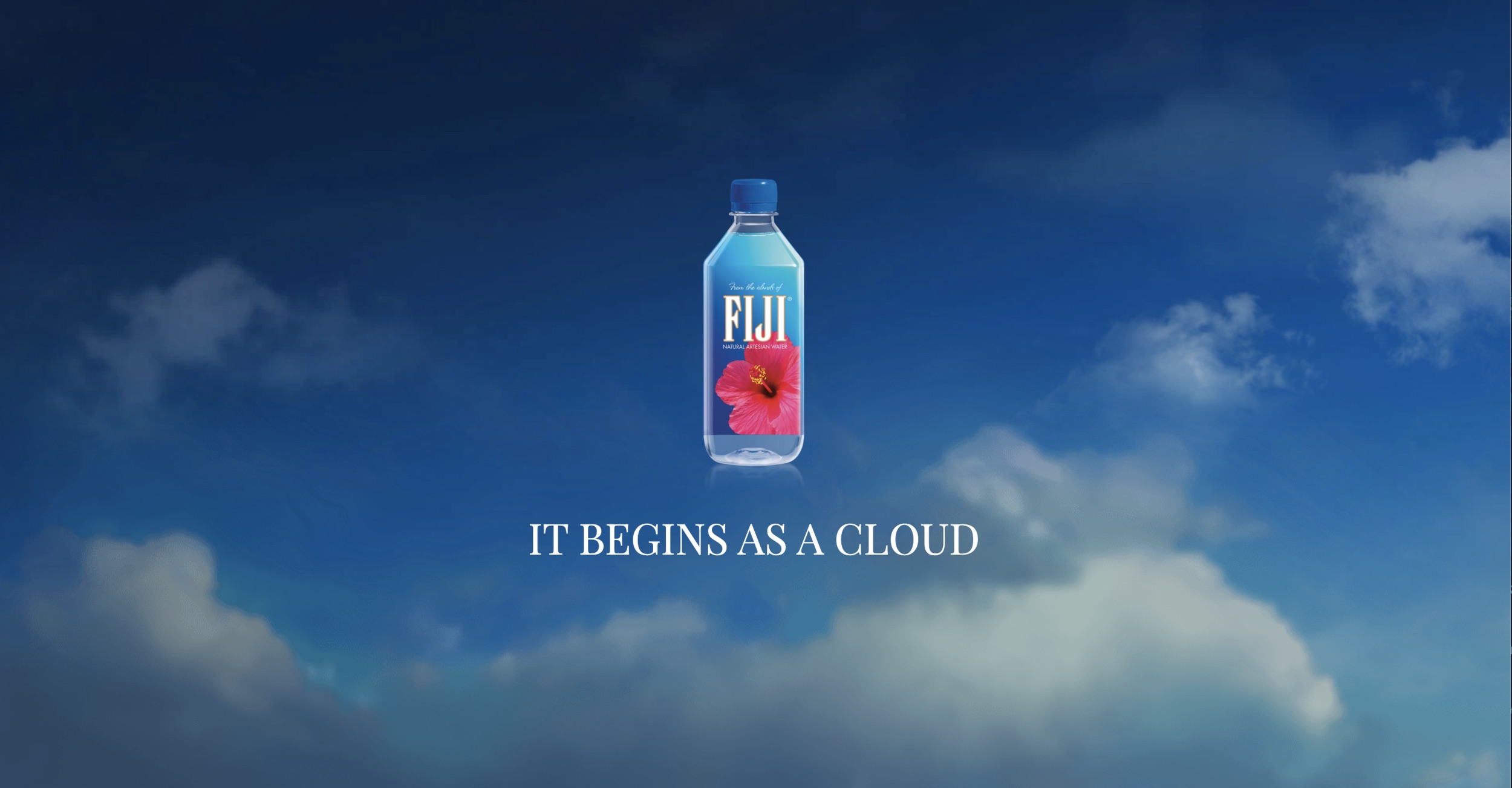 FIJI Water bottle suspended against an expansive blue sky